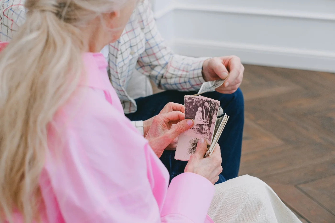 Two older adults looking through printed photographs